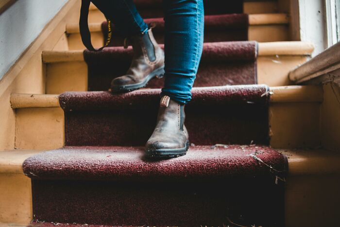 Person descends dusty stairs in haunted house.