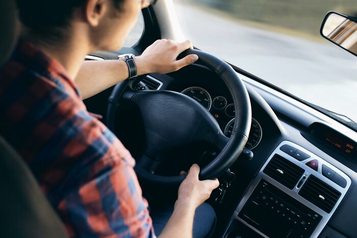 Person driving a car, gripping the steering wheel, illustrating unexplainable and disturbing human behavior moments.