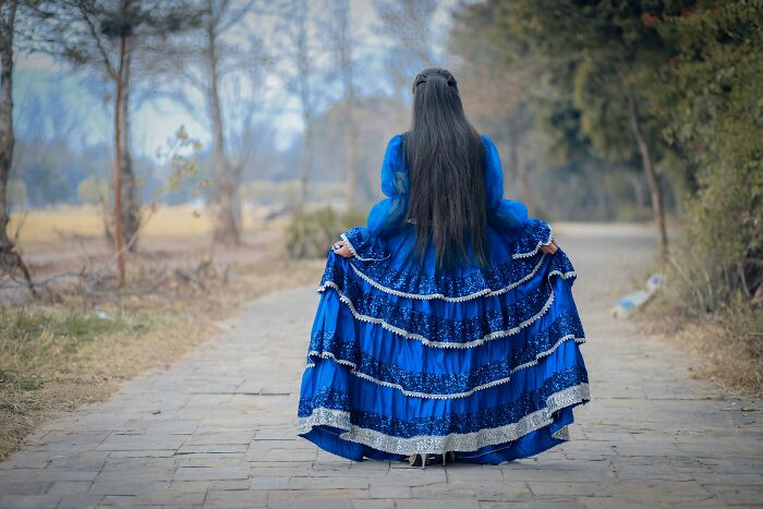 Person in a blue dress on a path.