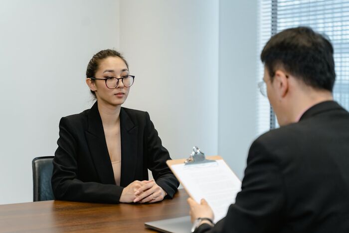 Two professionals in a formal meeting, highlighting social norms in workplace interactions.