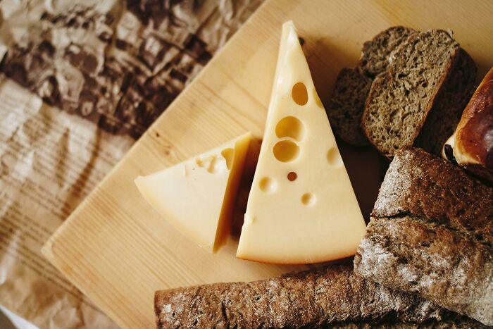 Cheese with bread on a wooden board.