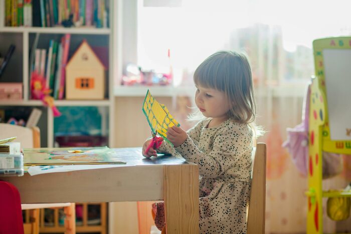 Child drawing at a table in a sunlit room, highlighting middle class affordability concerns.