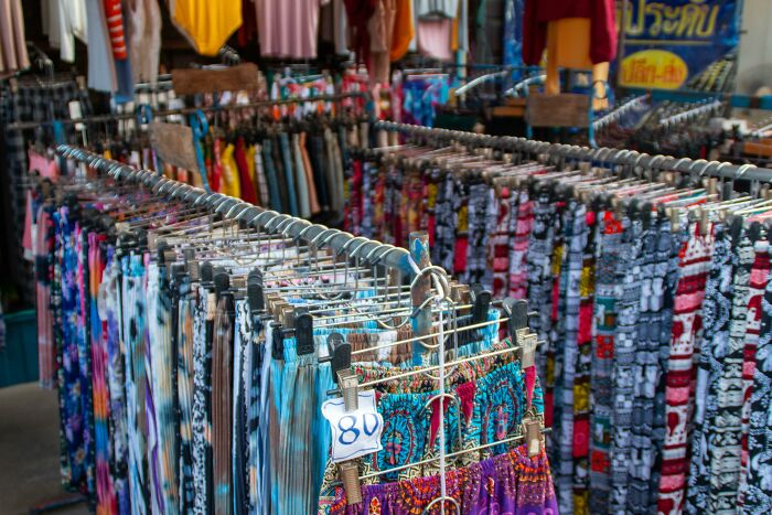 Colorful clothes on racks at a thrift store.