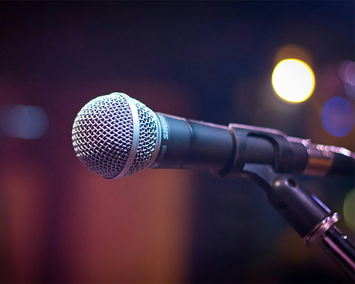 Microphone on stage ready for performers singing at the inauguration with blurred lights in the background.