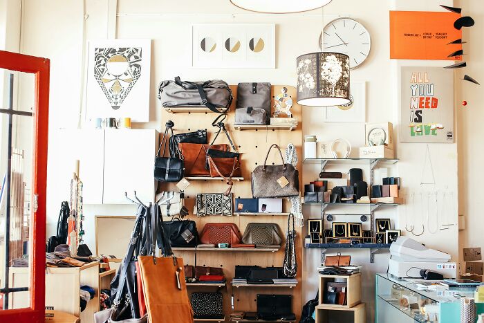 Thrifting shop with bags and accessories on shelves.