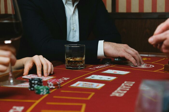 Poker table scene, featuring cards, poker chips, and a drink, illustrating a revengeful job exit.