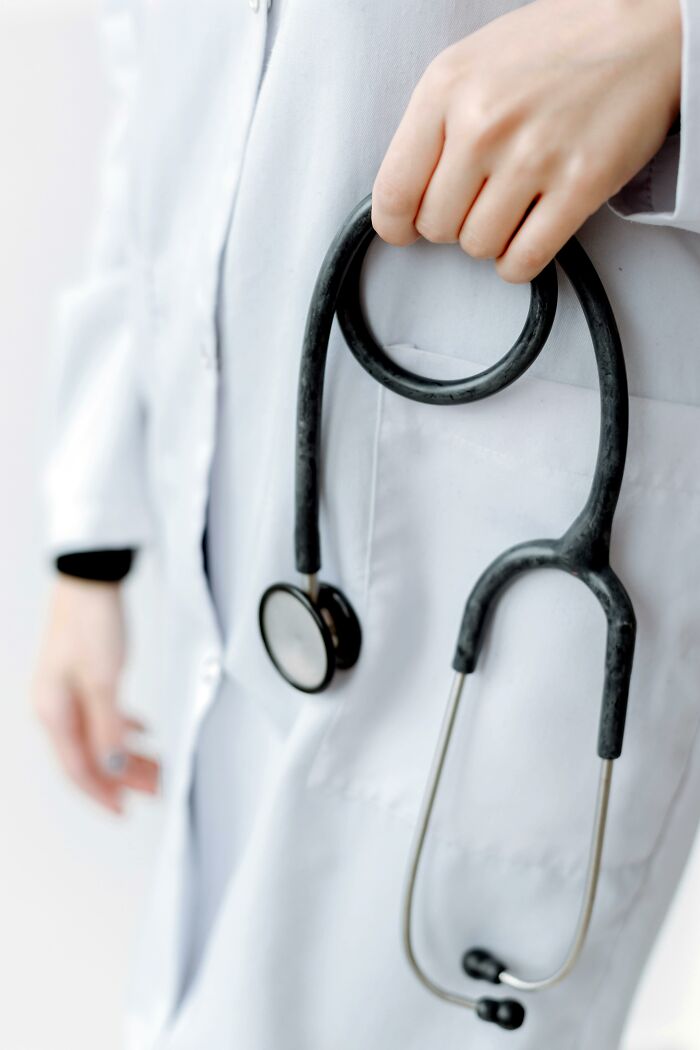 Doctor holding a stethoscope, wearing a white coat, focusing on healthcare professionalism.