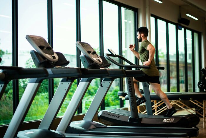 Man running on a treadmill in a gym.