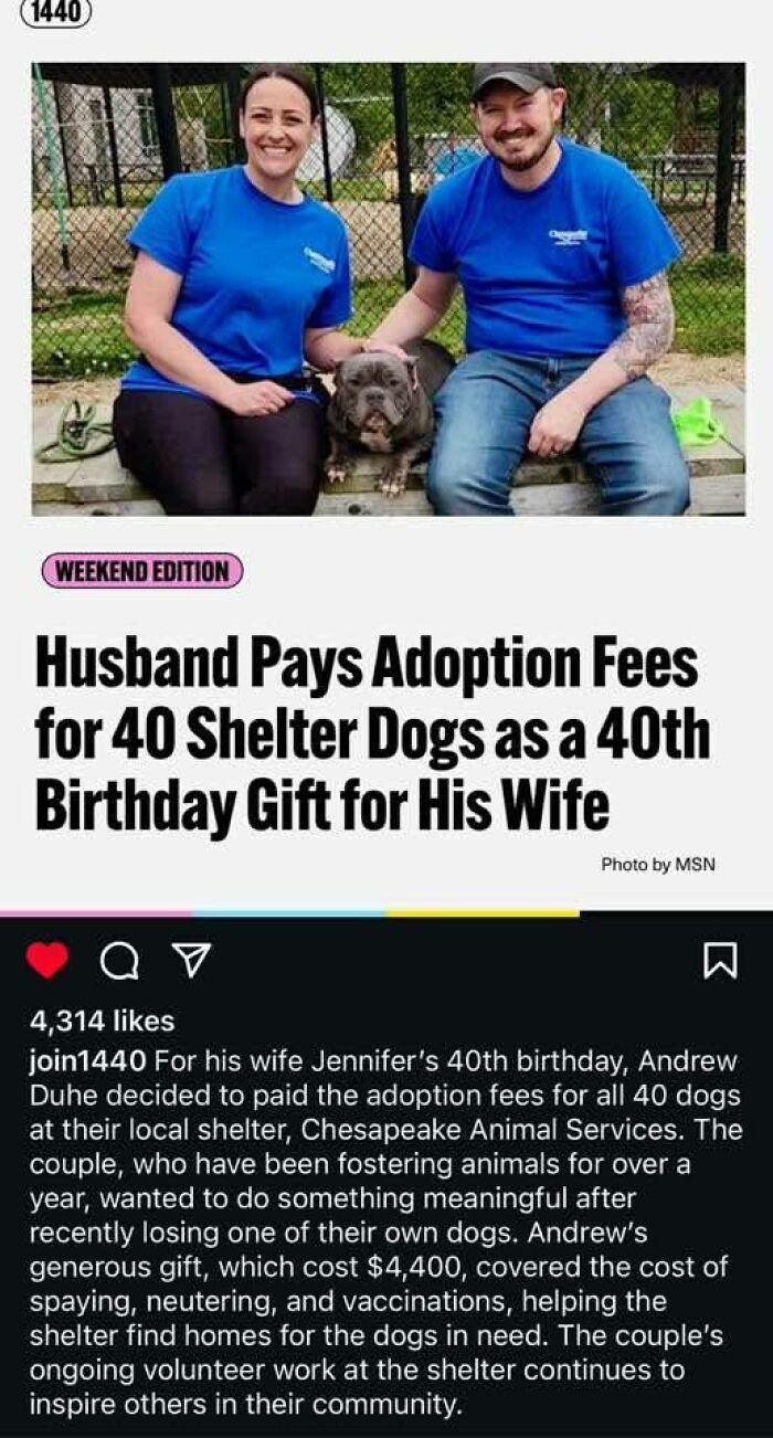 A couple in blue shirts smile with a dog at a shelter, showing kindness by paying adoption fees for 40 shelter dogs.