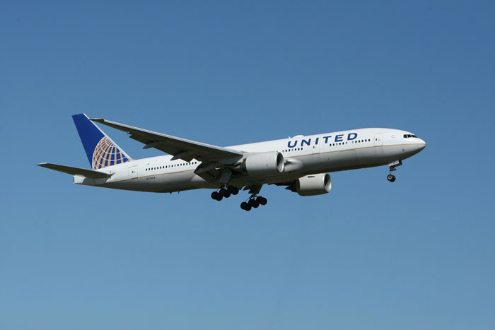 A United plane in mid-air on a clear day.