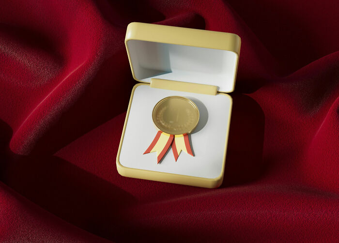 A gold medal with ribbons in a display box on a red velvet background, representing intriguing facts.