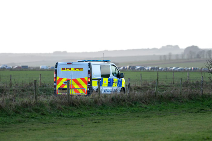 Police van parked in rural field, related to family and malnourished arranged marriage bride case.