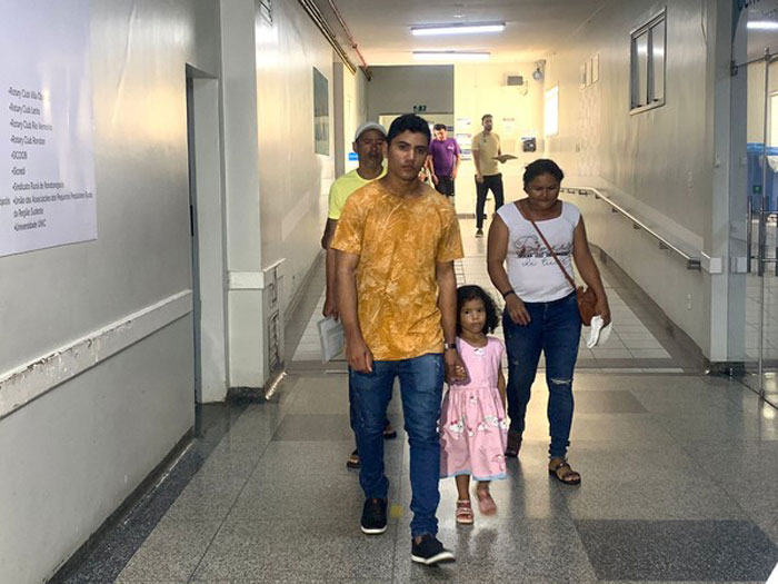 Family walking through hospital corridor amidst a devastating period concerning a pregnant woman on life support.