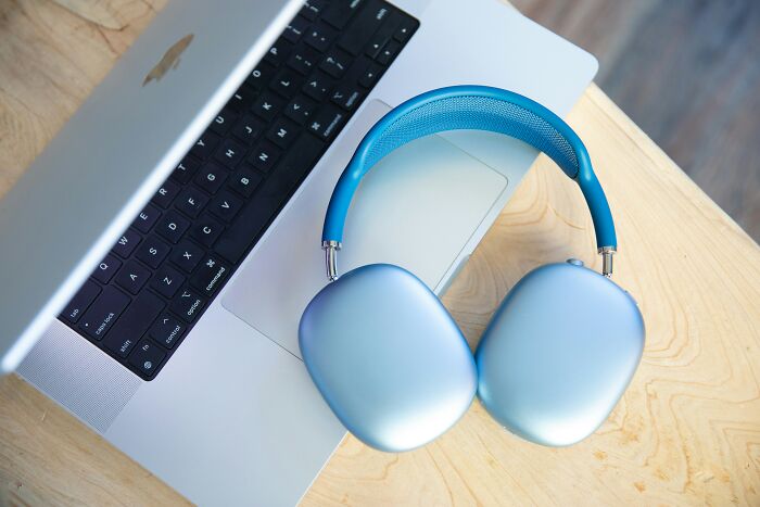 Silver and blue headphones on a laptop, illustrating expensive items worth investing in.