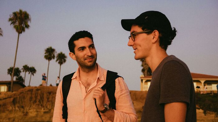 Two people having a conversation outdoors, displaying psychological tricks through engaged body language.