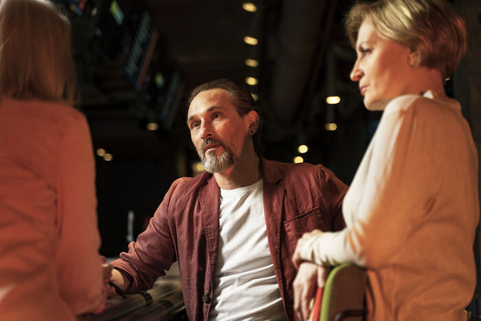 Three people in a discussion, illustrating psychological tricks in social interactions.