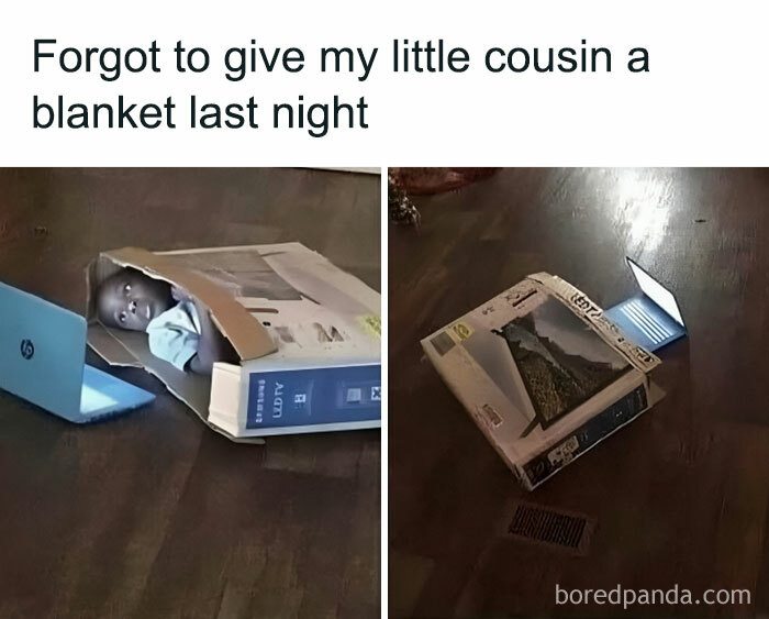 A child lying in an empty box beside a laptop.