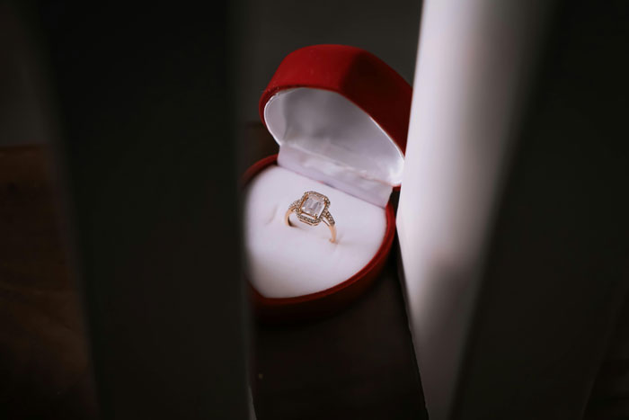 Engagement ring in a red velvet box, symbolizing a romantic proposal anniversary setting.