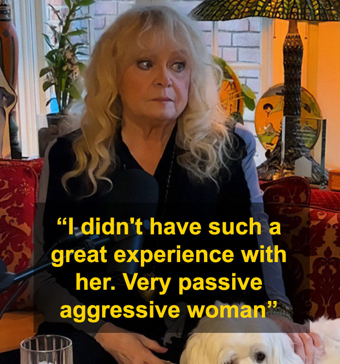 A woman sitting indoors with a surprised expression, next to lamps and plants, reflecting on passive-aggressive behavior.