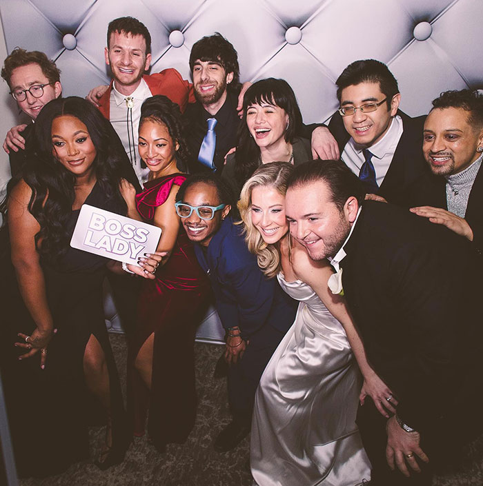 Group photo at a wedding with former child stars from School of Rock, smiling and posing together in formal attire.