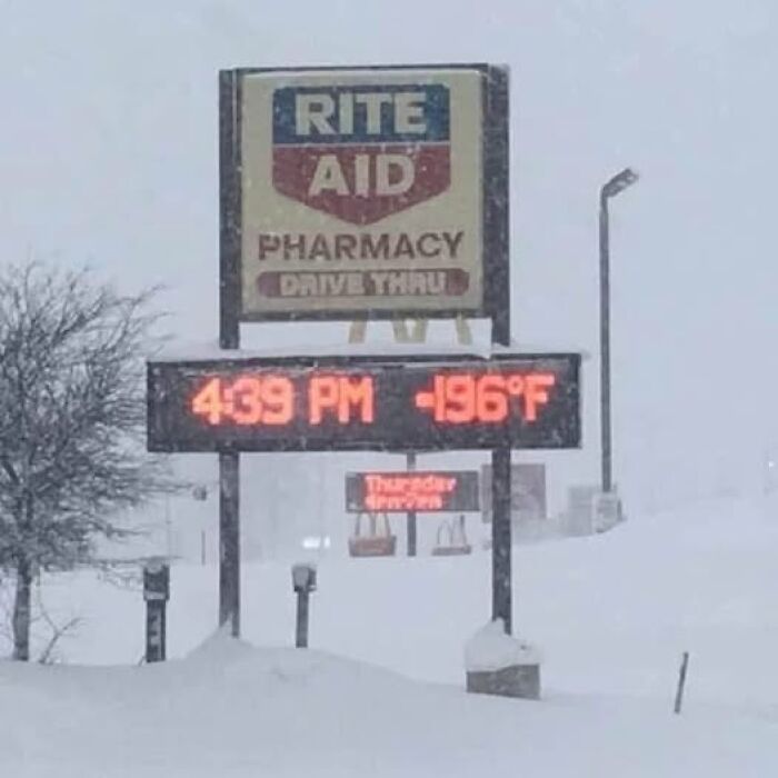 Rite Aid sign showing -196°F during snowstorm, creating a humorous science meme effect.