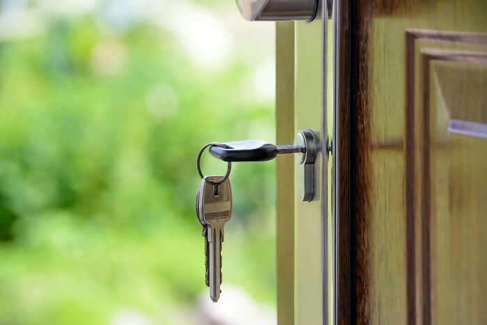 Key in a door lock symbolizing home security and protection against scammers.