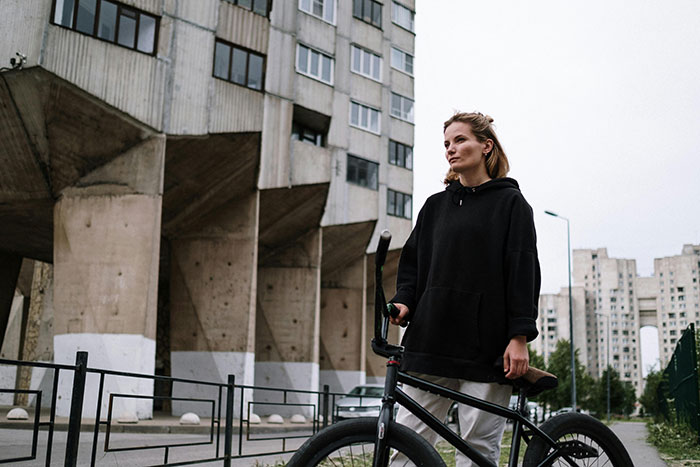 Woman in urban setting with a bike, associated with a spoiled brat incident in a minor disagreement.