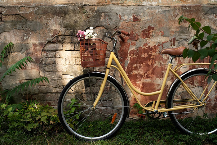 Yellow bike with a basket of flowers against a rustic wall, symbolizing a spoiled brat incident.