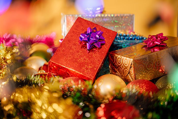 Christmas presents with colorful bows surrounded by festive decorations.