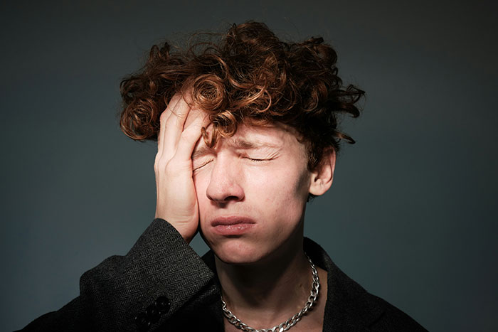 Young man with a hand on his face, reflecting on treasure discovery.