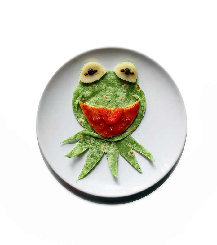 Playful food art using fresh ingredients, shaped like a cartoon frog on a plate.