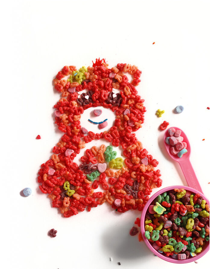 Playful food art design of a cartoon bear made with colorful cereal and fresh ingredients.