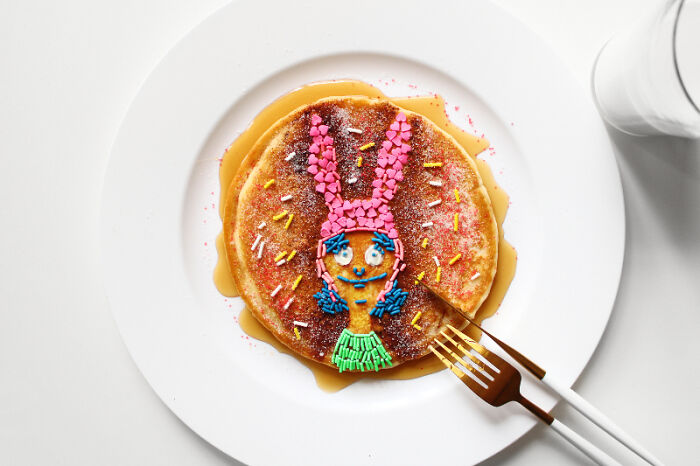 Playful food art design inspired by cartoons on a pancake, made with fresh ingredients.