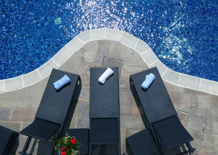 Poolside loungers at a resort with rolled towels; petty revenge setup against selfish people.