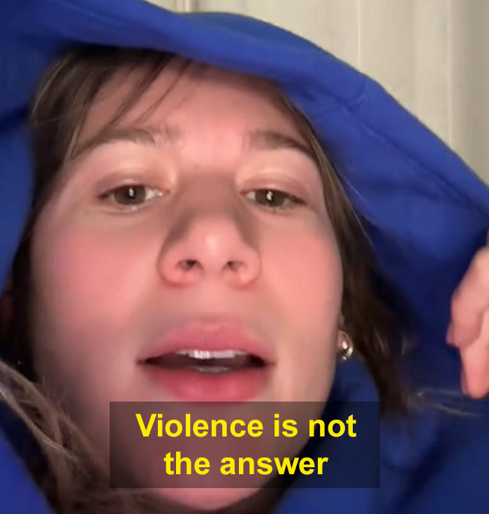 Person in a blue hoodie with "Violence is not the answer" text, discussing lack of sympathy for CEOs.