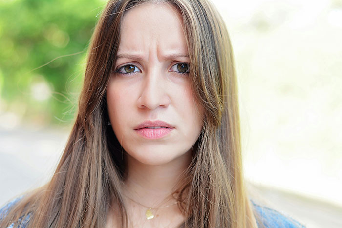 Woman with a concerned expression, illustrating discomfort with creepy behavior from men.