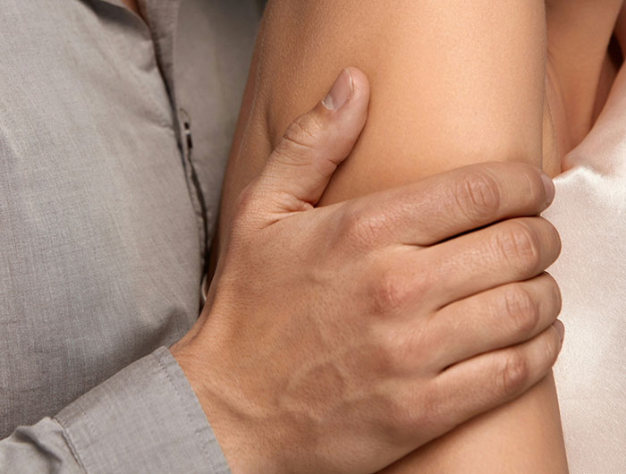 Man's hand gripping a woman's arm in a potentially uncomfortable manner, illustrating creepy behavior.