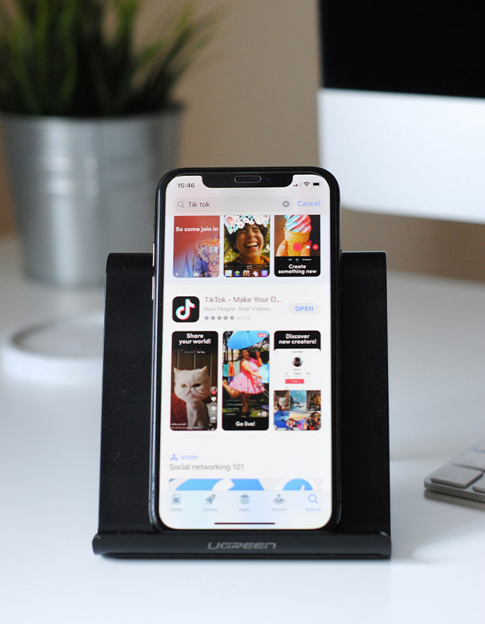 Smartphone displaying TikTok app on a stand, highlighting the TikTok ban discussion.