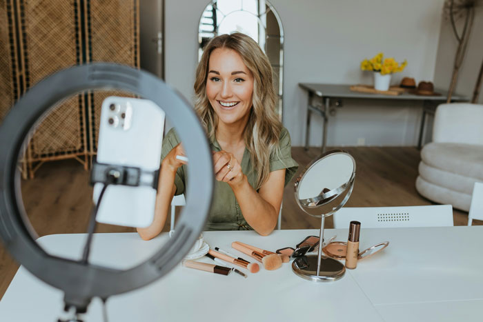 Woman filming makeup tutorial at home amid TikTok ban discussions.