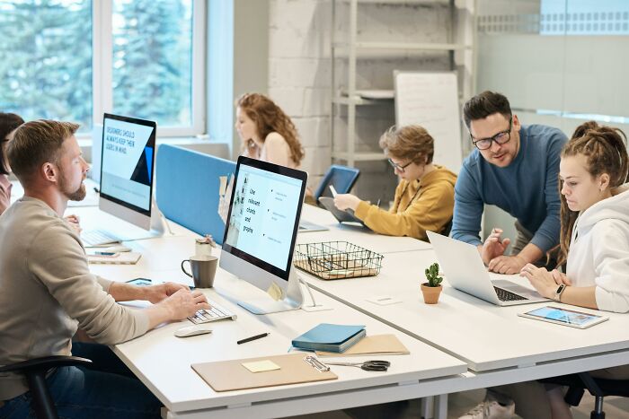 People collaborating in a modern office, working on computers and sharing new facts.