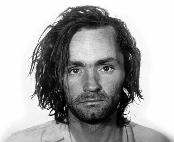 A black and white mugshot related to true crime cases, featuring a person with unkempt hair and a solemn expression.