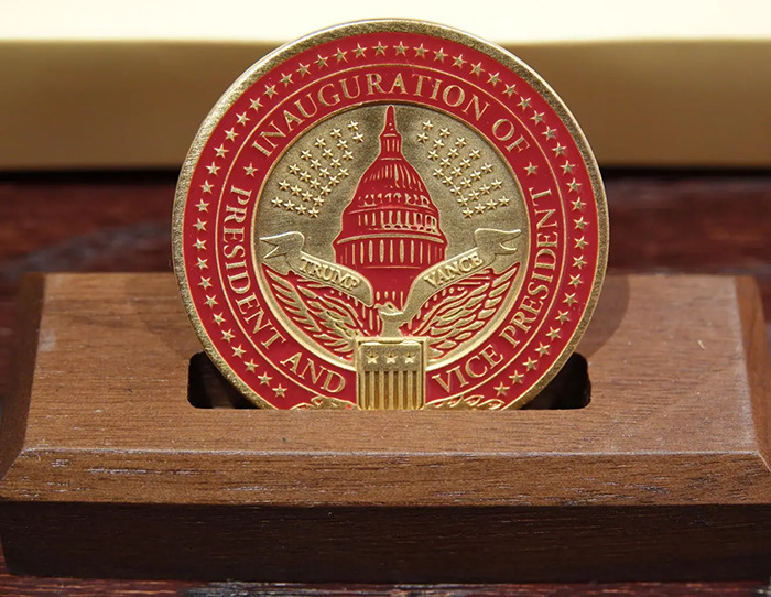 Inauguration coin from VIP goodie bags at Trump event, featuring red and gold design with presidential seal.