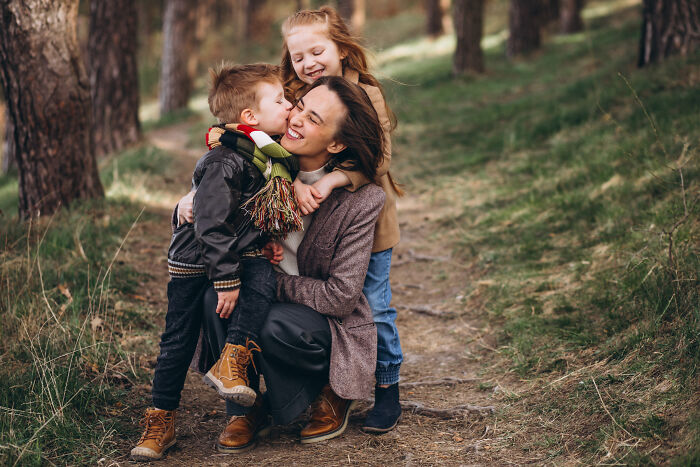 Family enjoying a moment on a wooded path, highlighting friendship and connection.