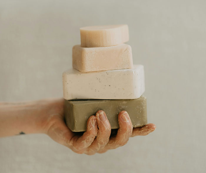 "Hand holding stacked soaps, illustrating unspoken hotel etiquette."