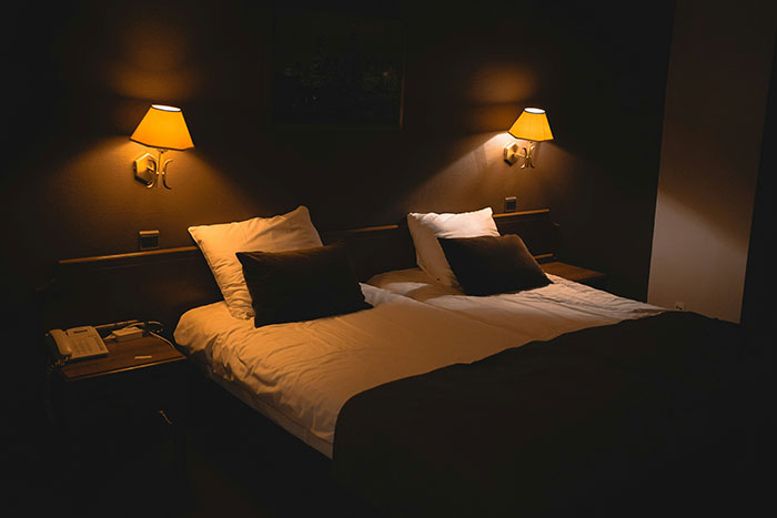 Cozy hotel room with twin beds, warm lighting, and bedside lamps, exemplifying hospitality standards.