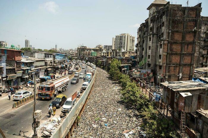 Urban hell scene with crowded street, decaying buildings, and litter-strewn area, exemplifying urban decay.