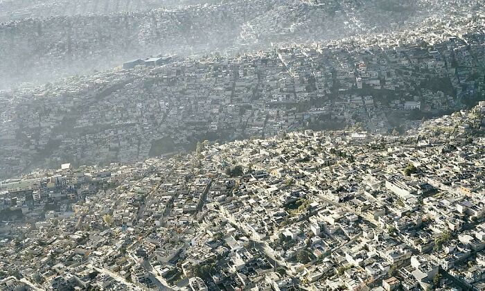 Aerial view of densely packed buildings exemplifying urban hellscape under a hazy sky.