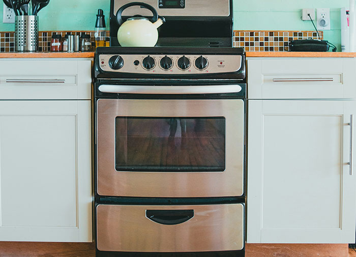 Stove used as a storage space, illustrating using things the wrong way in a kitchen setting.