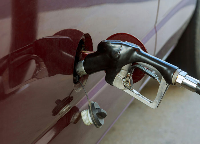 Fuel nozzle inserted into a car door handle, illustrating using things wrong.