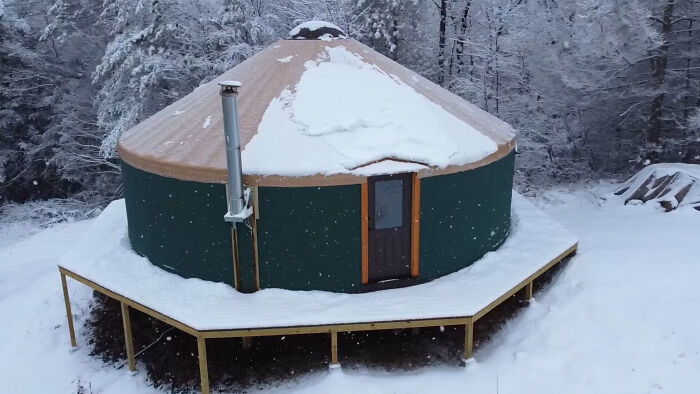 Off-grid yurt built by a couple in a snowy forest setting.